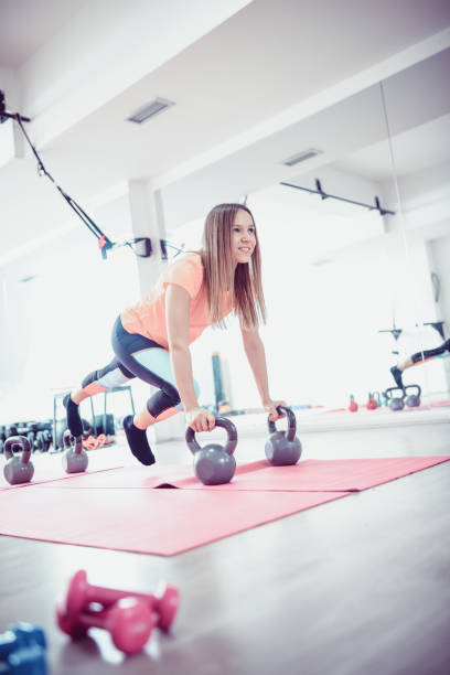 istock One Persistent Girl Making Difficult Push Up Exercise on Kettlebell in The Gym 919164962