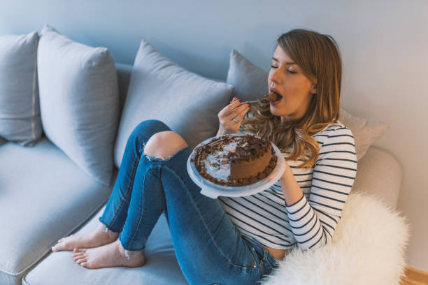 Closeup of woman eating chocolate cake. Beautiful girl enjoys eating a cake with chocolate. Pretty young woman eats a sweet cake. food, junk-food, culinary, baking and holidays concept. woman eating chocolate cake with spoon