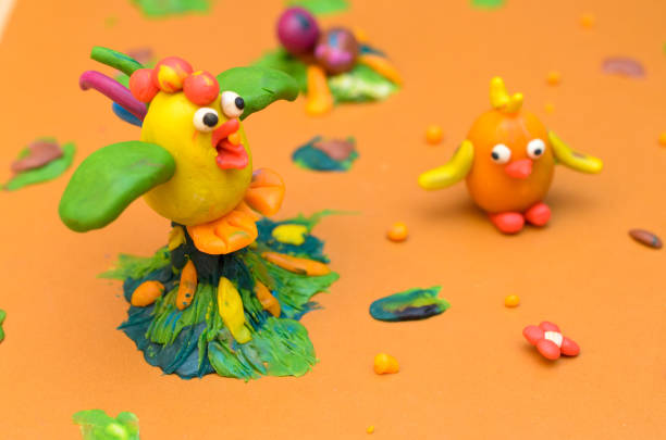 istock Rooster and chicken from plasticine on a yellow background. 919179540