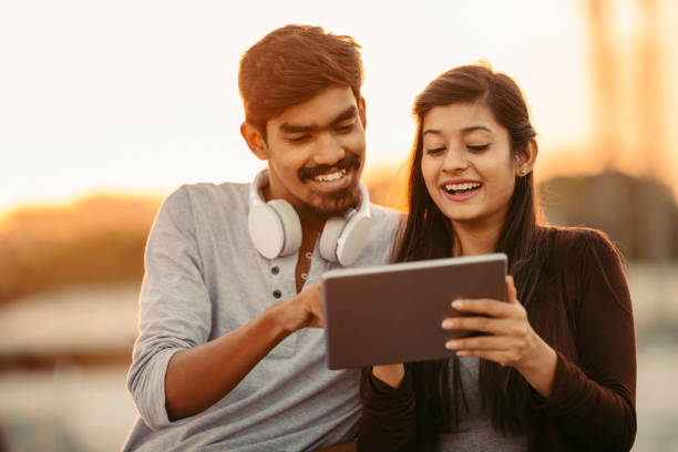 istock Happy young friends using tablet with headphones 919181124