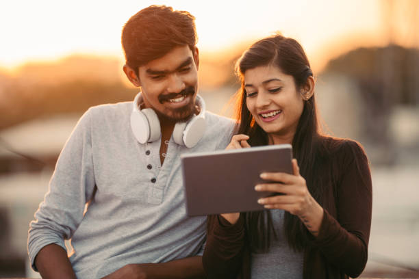 istock Happy young friends using tablet with headphones 919181126