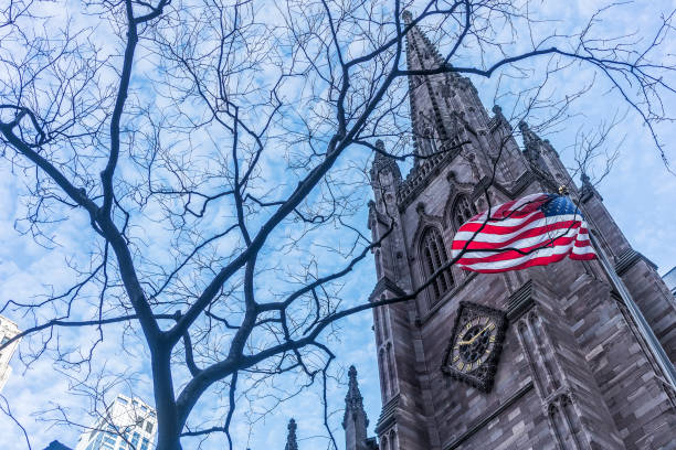 istock American flag with buildings behind. 919197740