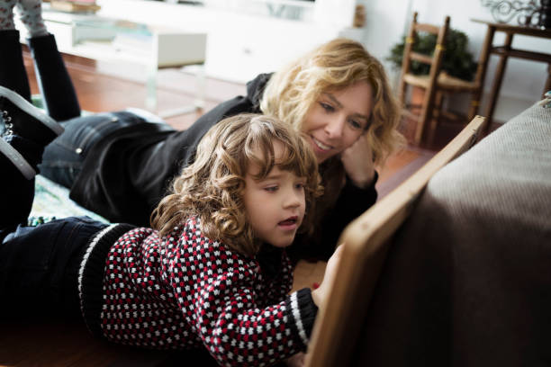 istock Child with mother drawing on blackboard at home 919198738