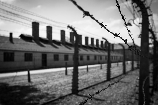 Auschwitz, Poland - May 25, 2016: Barbed wire fence at the Auschwitz concentration camp, the biggest extermination camp in Europe built by Nazi.