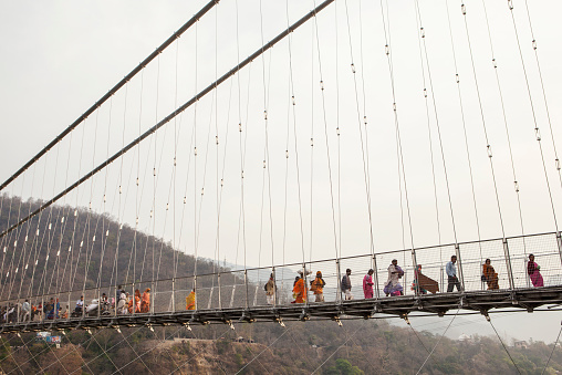 'Rishikesh, India - April 12, 2010: People walking on the bridge to Laksman Jhula during Kumbh Mela which took place in Haridwar, Rishikesh in 2010'