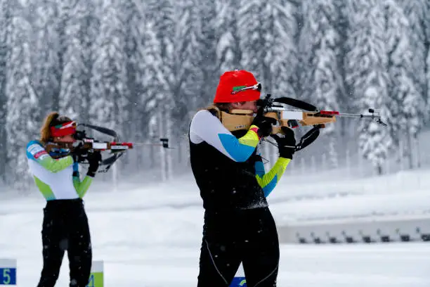 Young women practicing biathlon in snowstorm