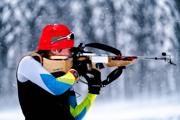 istock Side View of Female Biathlon Competitor Practicing Target Shooting in Snowstorm 919240426