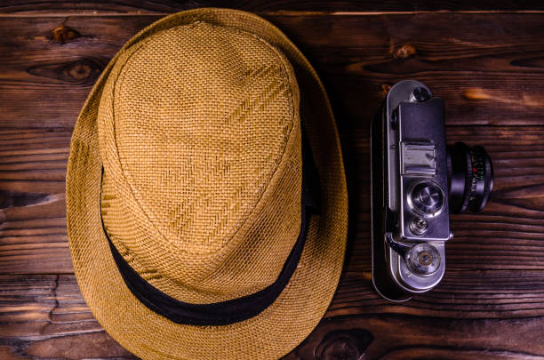 istock Old rangefinder camera and hat on a wooden table. Top view 919246500