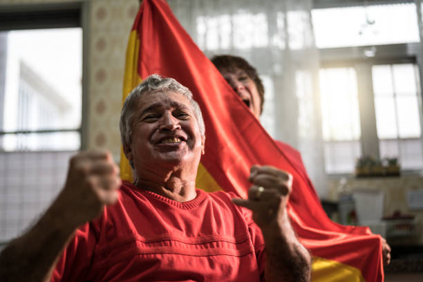 istock Spanish senior couple fan watching soccer game at home 919256878