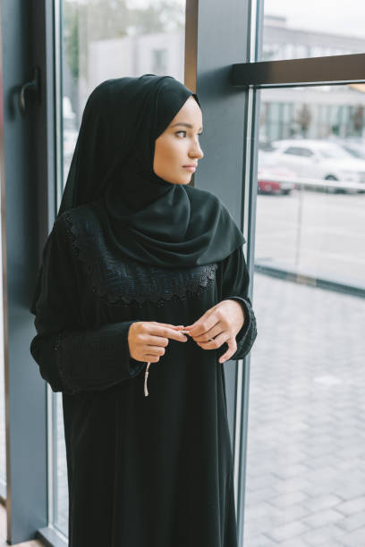 istock muslim woman looking at window 919291098