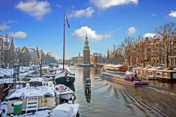 снежный амстердам с башней монтельбаан зимой в нидерландах - montelbaan tower стоковые фото и изображения