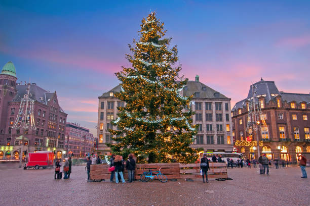 amsterdam in der weihnachtszeit auf dem dam in den niederlanden bei sonnenuntergang - dam stock-fotos und bilder