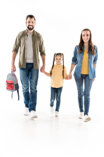 istock parents holding hands with schoolgirl 919309420