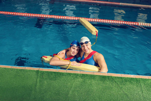 two trainers in a pool with rescue equipment - lifeguard association imagens e fotografias de stock