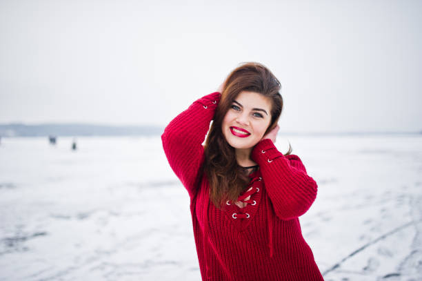istock Brunette plus size model at red against frozen lake on winter day. 919313634