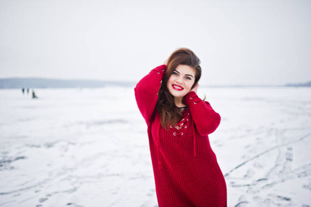 istock Brunette plus size model at red against frozen lake on winter day. 919313676