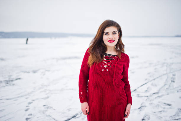 istock Brunette plus size model at red against frozen lake on winter day. 919314934