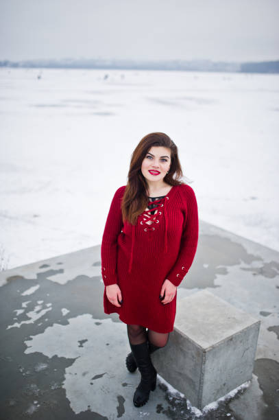 istock Brunette plus size model at red against frozen lake on winter day. 919315766
