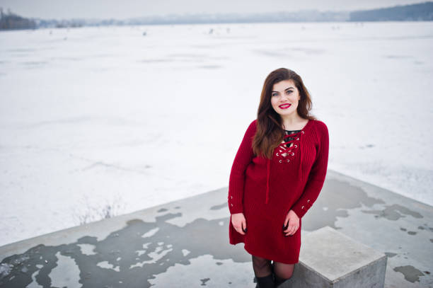 istock Brunette plus size model at red against frozen lake on winter day. 919316526