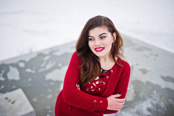 istock Brunette plus size model at red against frozen lake on winter day. 919317800