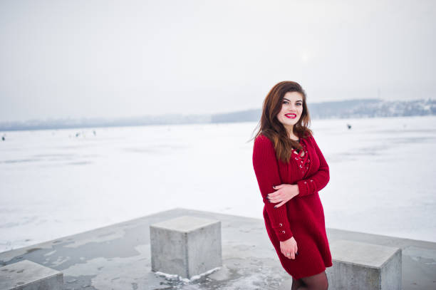 istock Brunette plus size model at red against frozen lake on winter day. 919317814