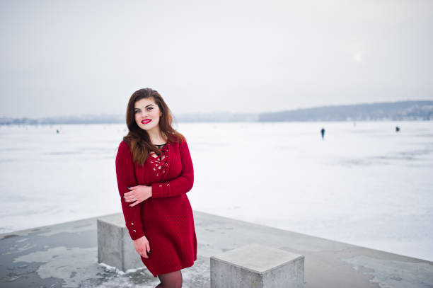 istock Brunette plus size model at red against frozen lake on winter day. 919317818