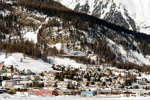 A private jet landing to St Moritz airport in snowy mountains in the alps switzerland