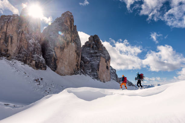 Skiers Touring Around the Cime in Dolomites, italy Side view of two young men ski touring in Dolomites, Italy, tre Cime in the background dolomites stock pictures, royalty-free photos & images