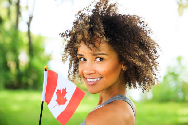 Young Proud Canadian Woman Happy young woman with Canadian flag outdoor portrait canada day photos stock pictures, royalty-free photos & images