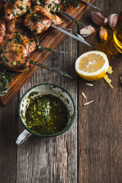 Chimichurri sauce in rural white mug Homemade chimichurri sauce in rural white mug on rustic wooden table, traditional marinade or sauce for grilled meat chicken skewer stock pictures, royalty-free photos & images