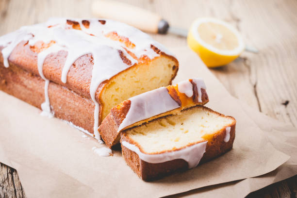 Lemon pound cake Homemade glazed lemon pound cake on rustic wooden table, sliced and ready to eat pound cake stock pictures, royalty-free photos & images