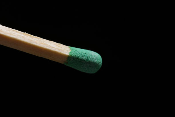 istock Unburnt matchstick with green head against black background 919369422