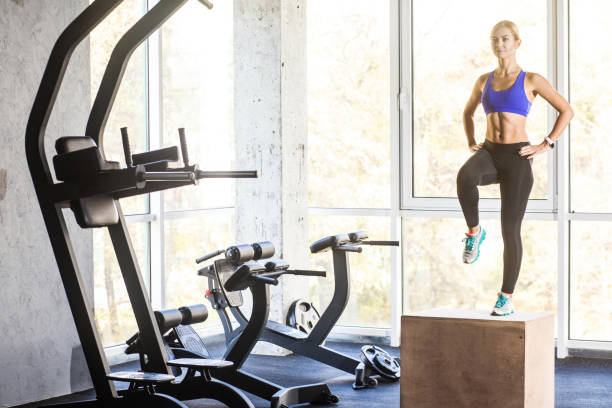 istock concept. Woman in gym step up on box 919374428