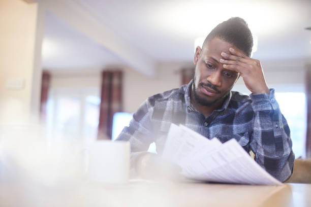 istock Worried young male reading through household bills 919382170