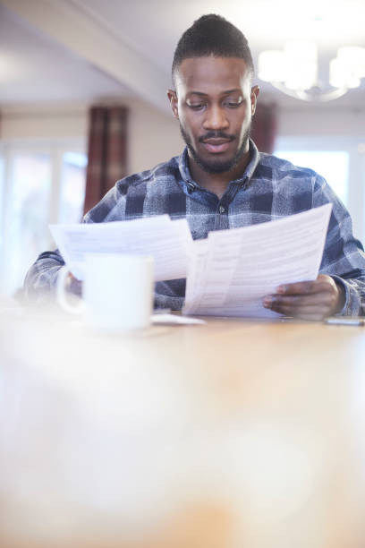 istock Young male reading through energy bills 919384996
