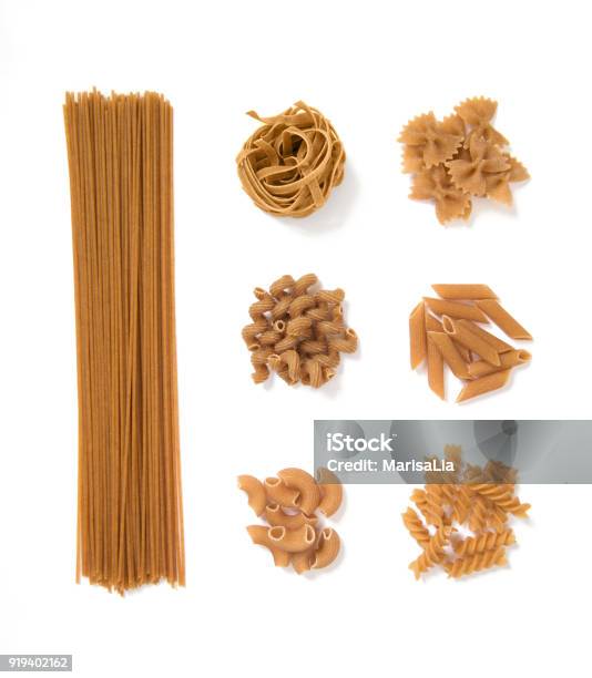 Selection Of Whole Grain Pasta Isolated On White Background Spaghetti Tagliatelle Farfalle Cellentani Penne Fussili Stock Photo - Download Image Now