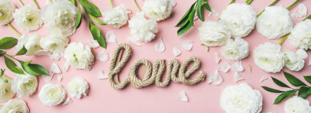 istock Saint Valentines Day background with ranunculus flowers and word love 919407502