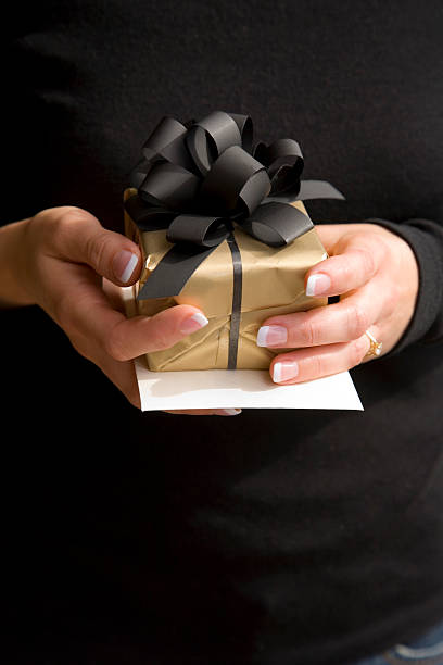 istock Female Hands Holding Gift With Black Ribbon 91940820