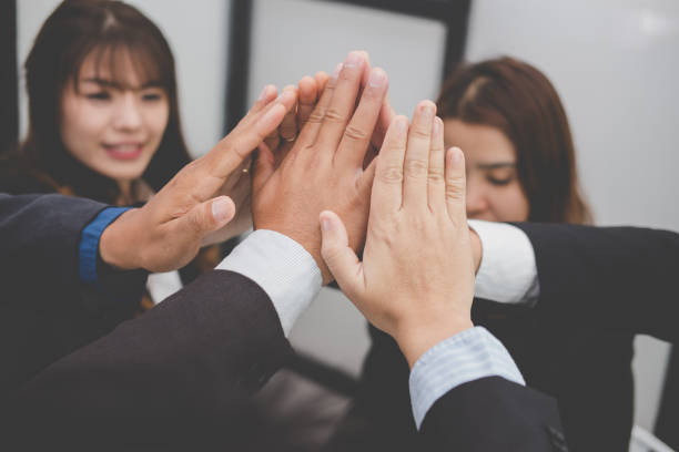 istock businessman joining hand, business team touching hands together - unity, harmony, teamwork, partnership, collaboration, corporate concept. 919415576