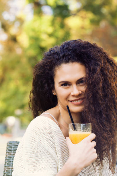 istock Beautiful woman drinking orange juice 919433164