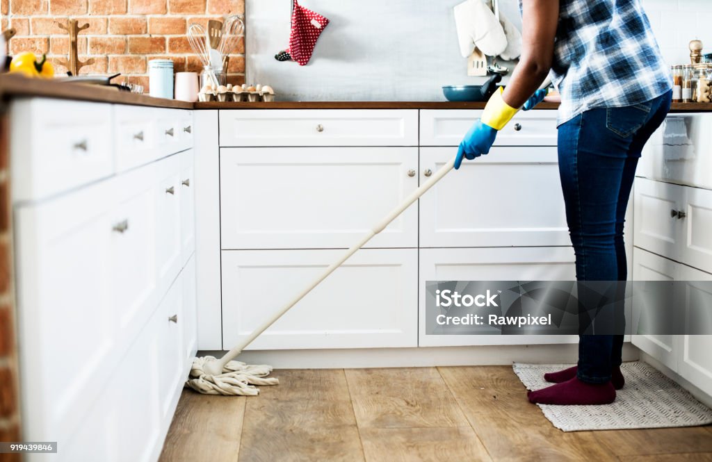 Black woman doing house chores Mop Stock Photo