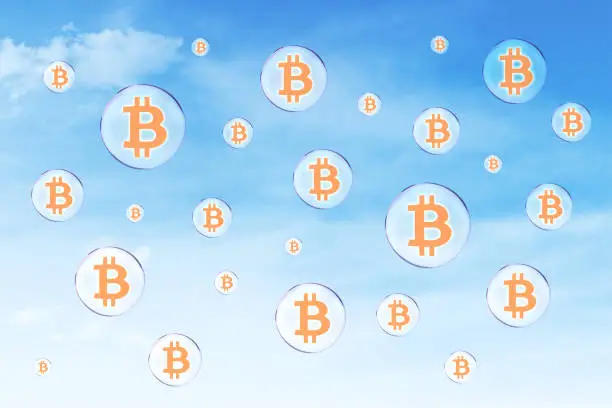 Picture of soap bubbles with bitcoin symbol flying on the blue sky