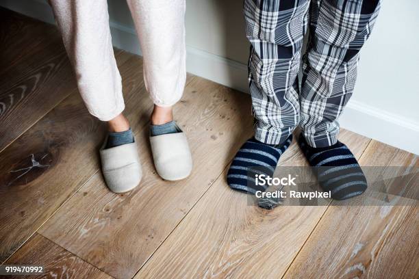 Closeup Of Couple Wearing Slippers On Wooden Floor Stock Photo - Download Image Now - Slipper, Men, House