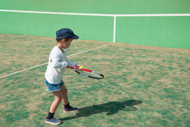istock Little girl playing tennis 919473378