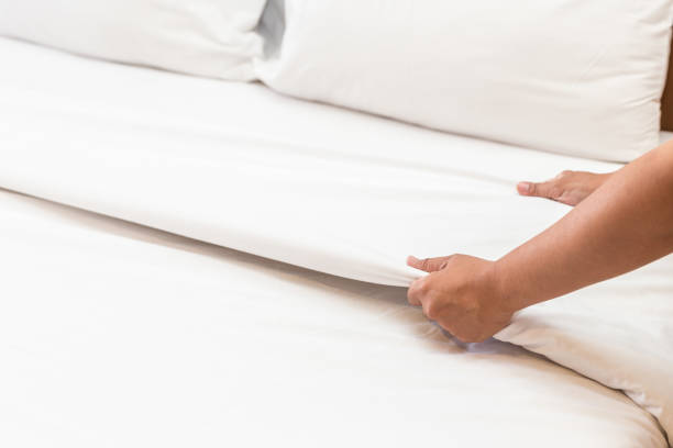 istock Hand set up white bed sheet in hotel room 919473506