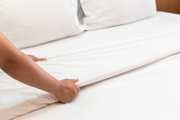 istock Hand set up white bed sheet in hotel room 919473550