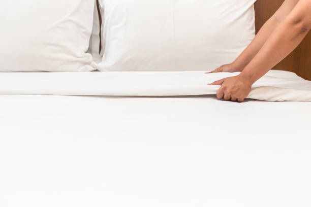 istock Hand set up white bed sheet in hotel room 919473616