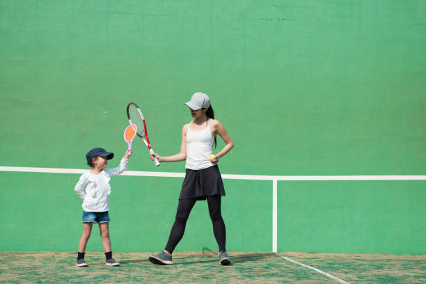 母と娘のテニスの練習 - tennis indoors women court ストックフォトと画像