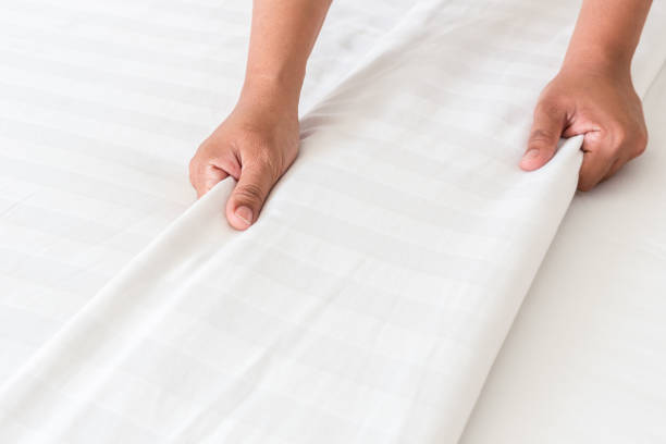 istock Hand set up white bed sheet in hotel room 919475952