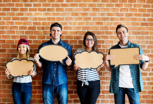 istock Happy young adults holding up copy space placard thought bubbles 919478996
